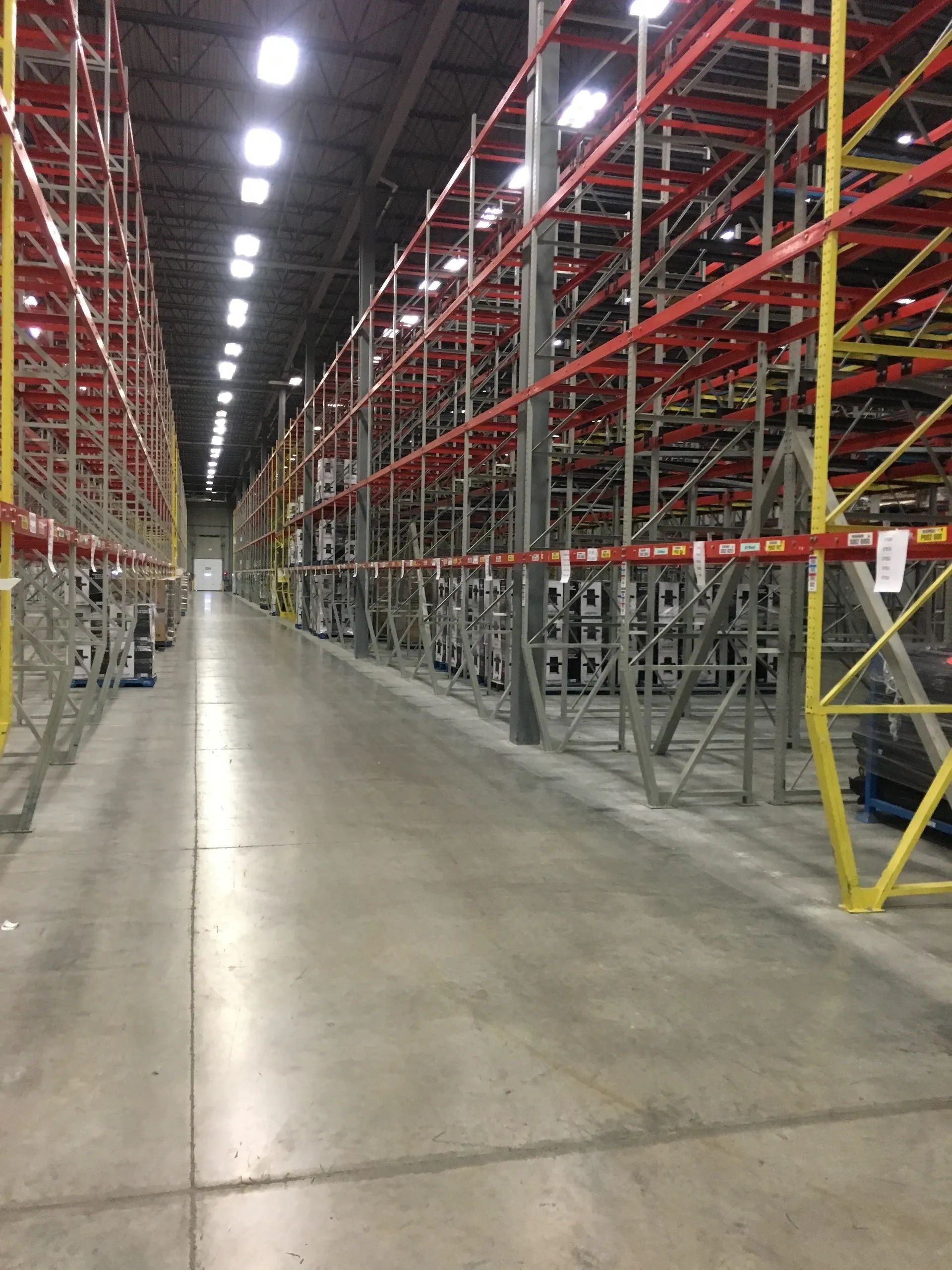 Large industrial warehouse interior with red and yellow pallet racking systems